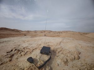 The radio, hand microphone, and antenna out among the yardangs.